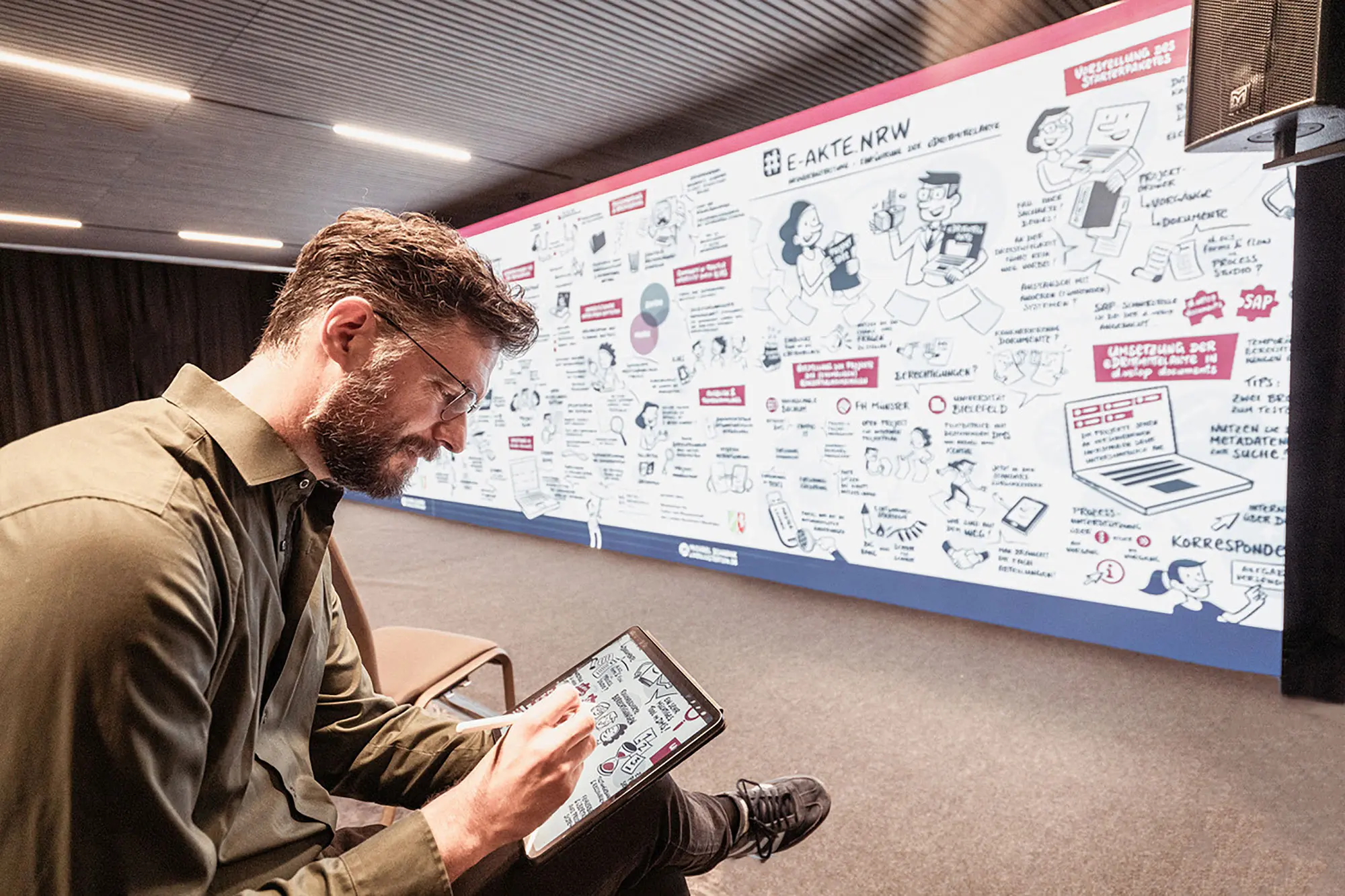 Michael Schrenk in Aktion beim digitalen Graphic Recording auf einer Veranstaltung